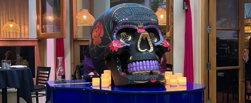 An ornate spice skull on top of the blue piano at Frida's of San Antonio